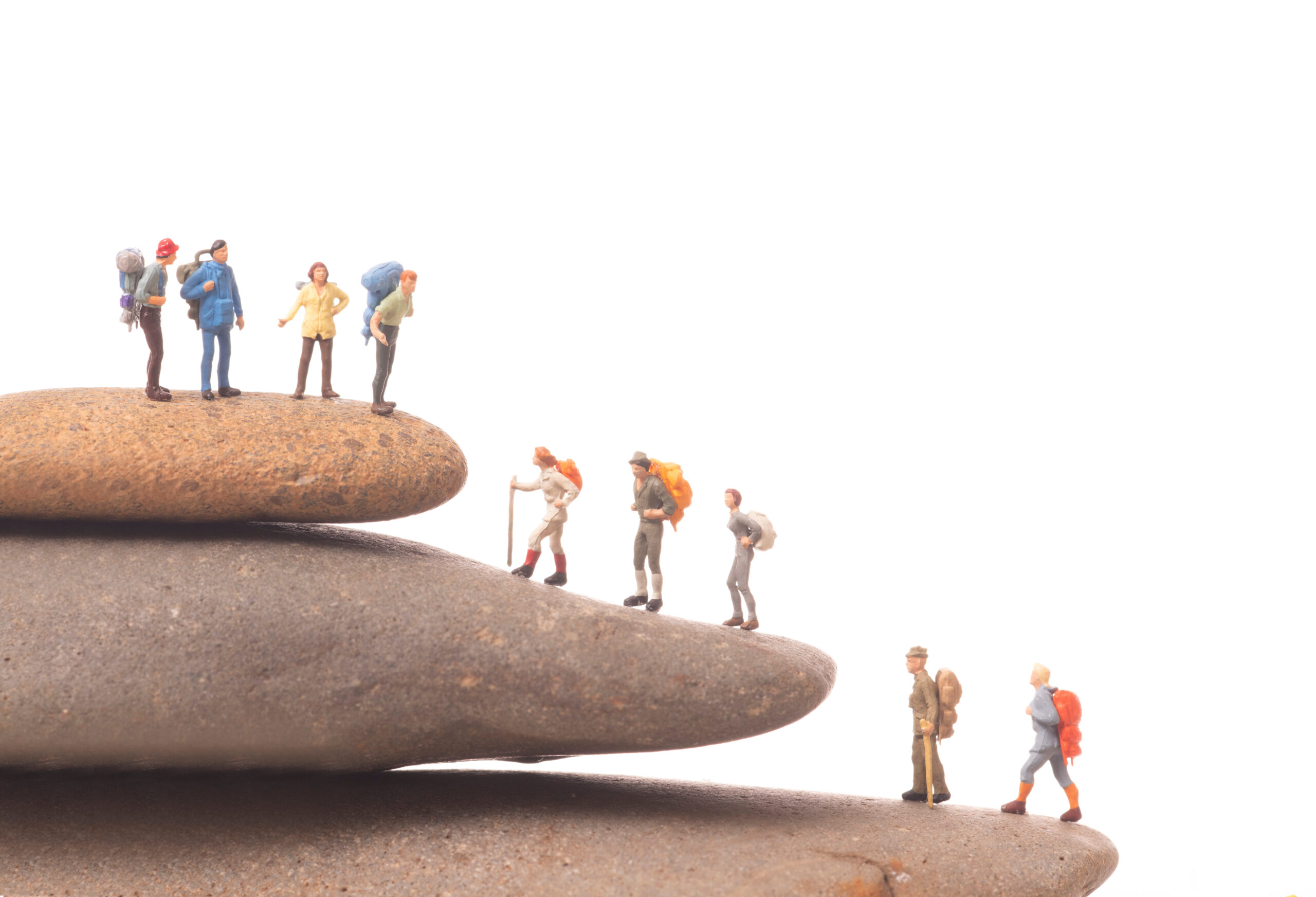 miniature people with standing on rock on white background